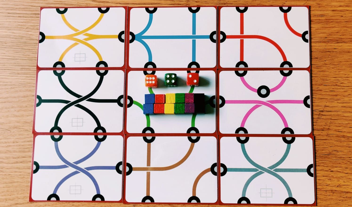 9 cards in 3x3 grid with dice and cubes on top