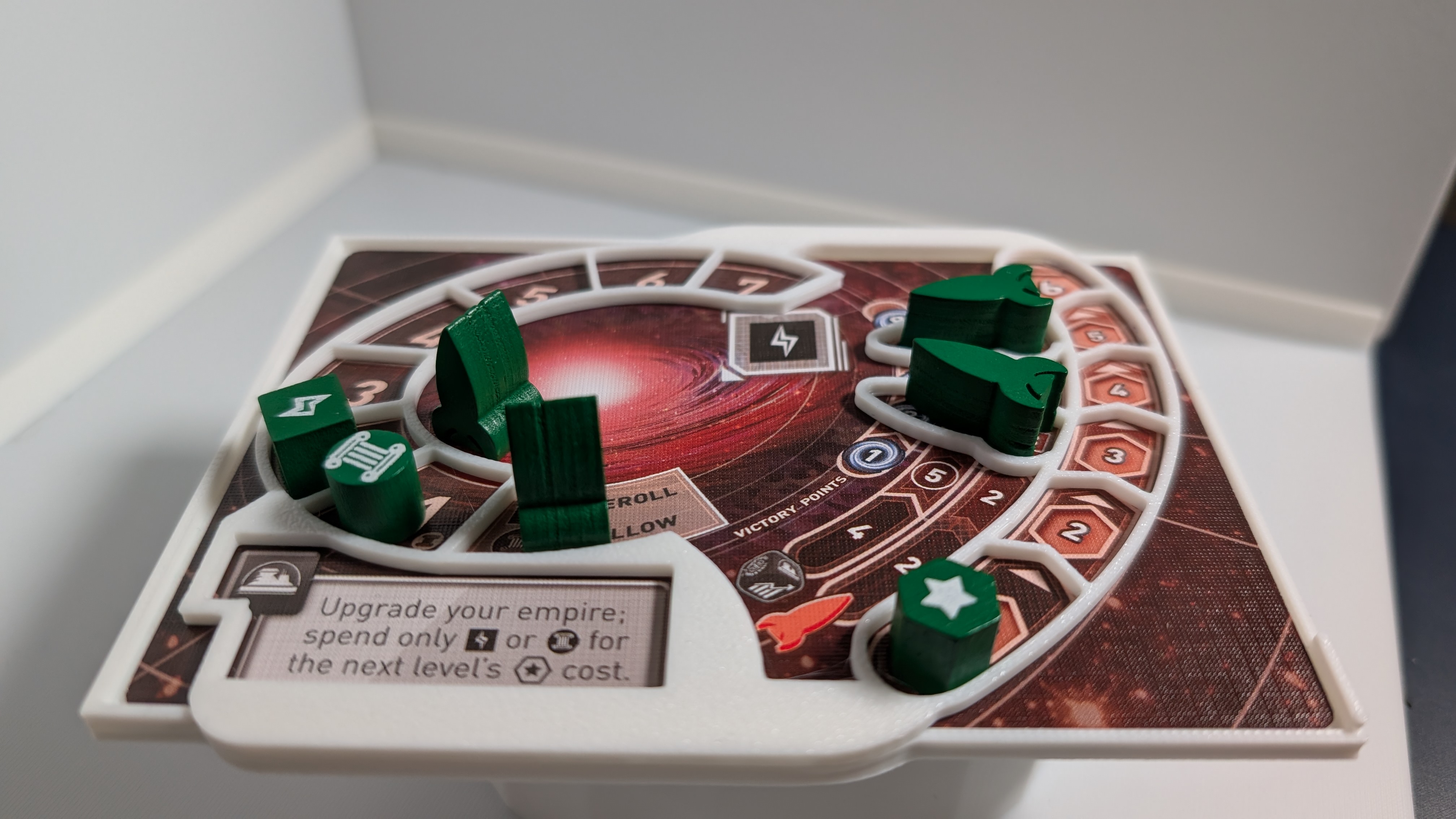 A 3D printed Tiny Epic Galaxies player mat overlay on a playmat with green tokens and spaceships on top. 