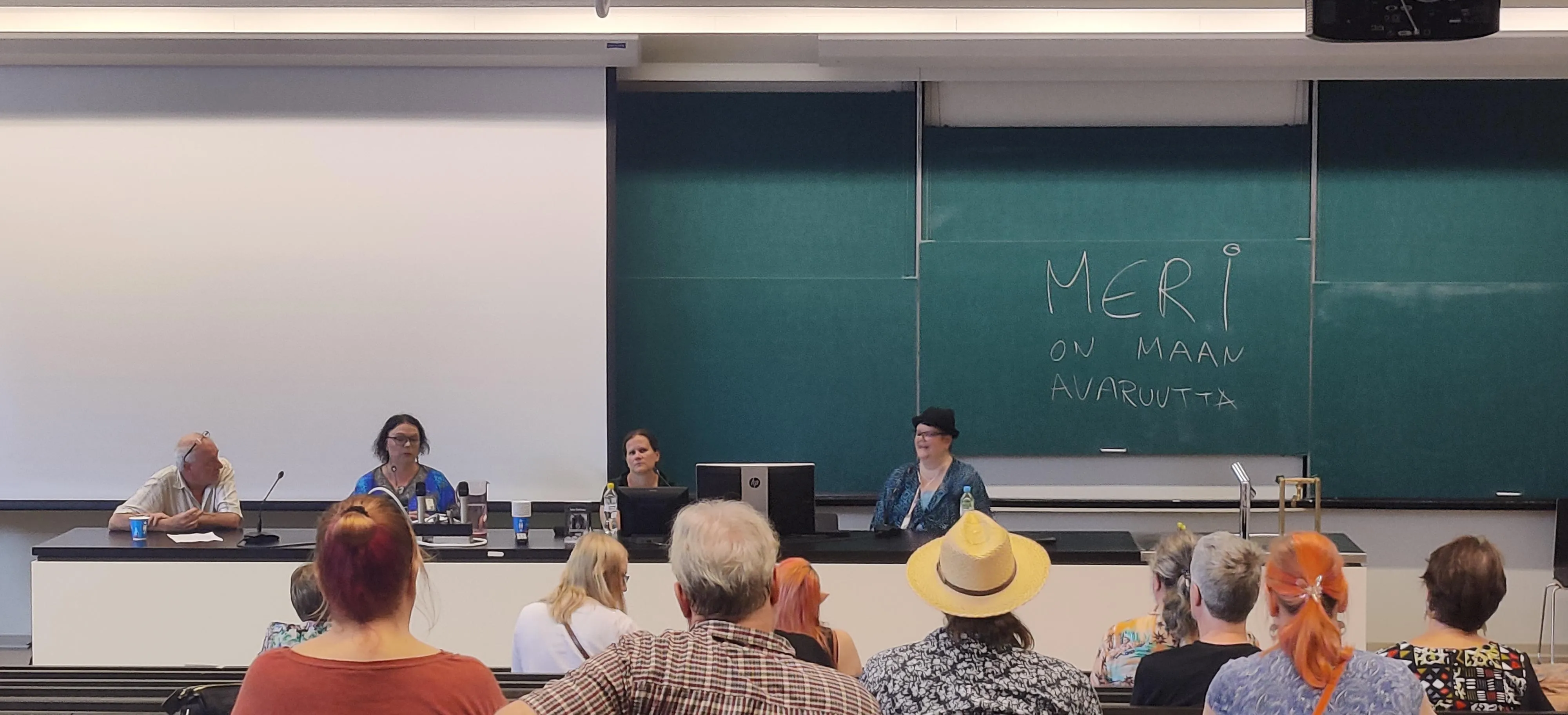 A panel discussion of four people in a university hall. 