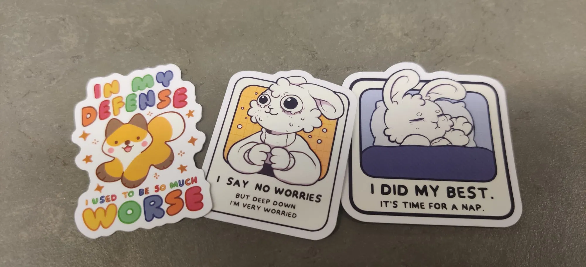 Three stickers: a happy fox with text In my defense, I used to be so much worse; a distressed rabbit with text I say no worries but deep down I’m very worried; and the same rabbit from previous but this time sleeping under a blanket with text I did my best. It’s time for a nap. 