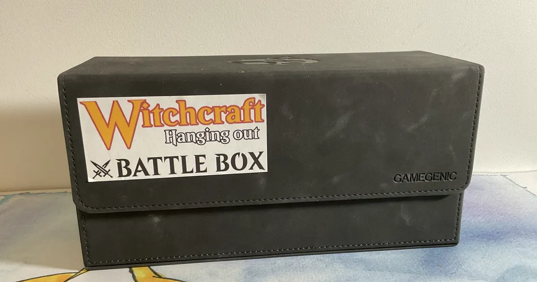 A dark grey GameGenic Academic 133+ XL deck box with a Witchcraft Hanging out Battle Box sticker 